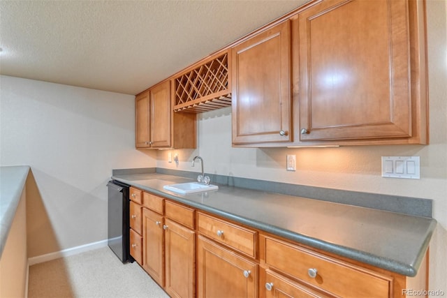 kitchen with dishwasher, sink, and a textured ceiling