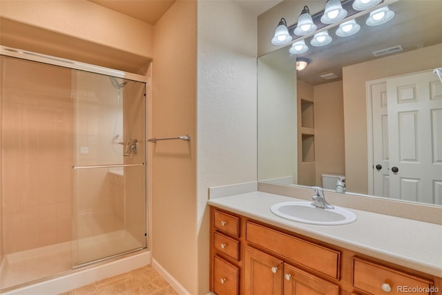 bathroom with tile patterned flooring, toilet, vanity, and walk in shower