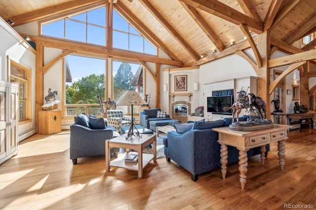 living room with baseboard heating, beamed ceiling, high vaulted ceiling, and light hardwood / wood-style floors