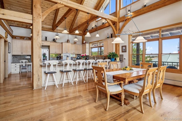 dining space featuring wooden ceiling, beamed ceiling, high vaulted ceiling, and light hardwood / wood-style floors