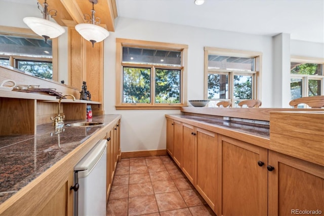 kitchen featuring dishwasher, decorative light fixtures, and sink