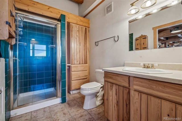 bathroom featuring vanity, toilet, a shower with shower door, and tile patterned flooring