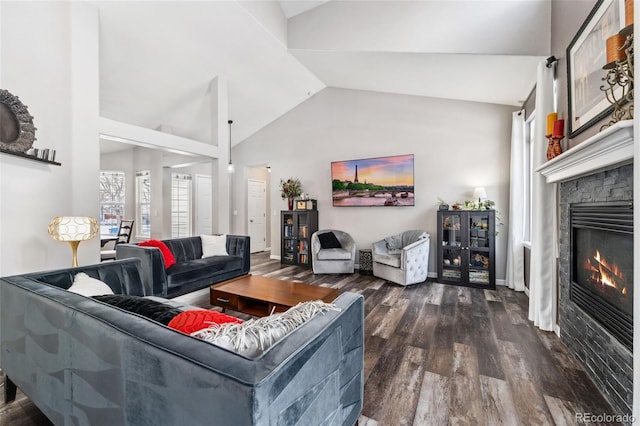 living room featuring a stone fireplace, dark wood-type flooring, and vaulted ceiling