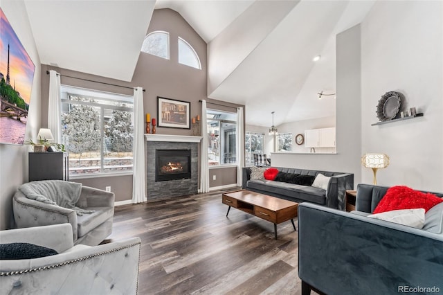 living room featuring dark hardwood / wood-style floors, lofted ceiling, and a tiled fireplace