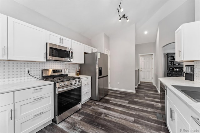 kitchen with backsplash, appliances with stainless steel finishes, dark hardwood / wood-style flooring, white cabinetry, and beverage cooler