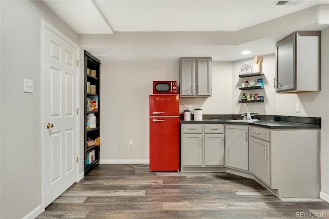 kitchen with dark wood-type flooring, gray cabinetry, and sink