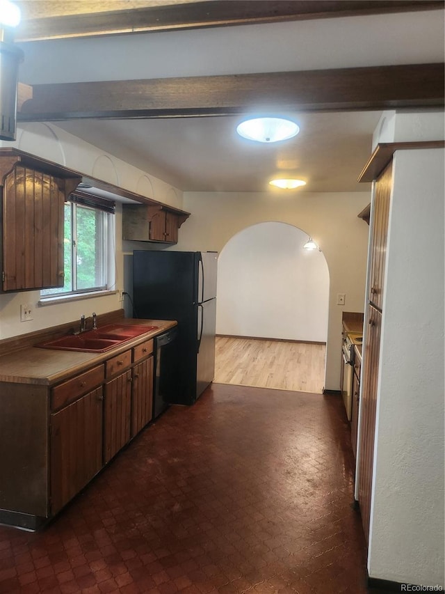 kitchen featuring sink, beam ceiling, black appliances, and wood-type flooring