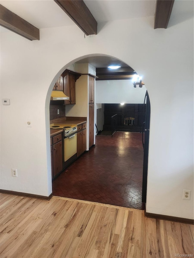 kitchen with beamed ceiling, electric range, premium range hood, and wood-type flooring