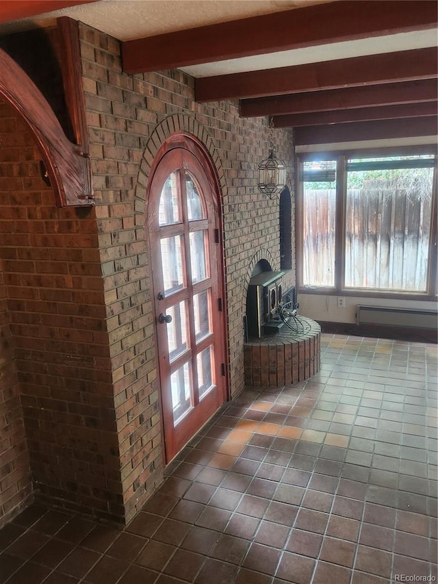 interior space with tile patterned flooring, beam ceiling, brick wall, and a wood stove