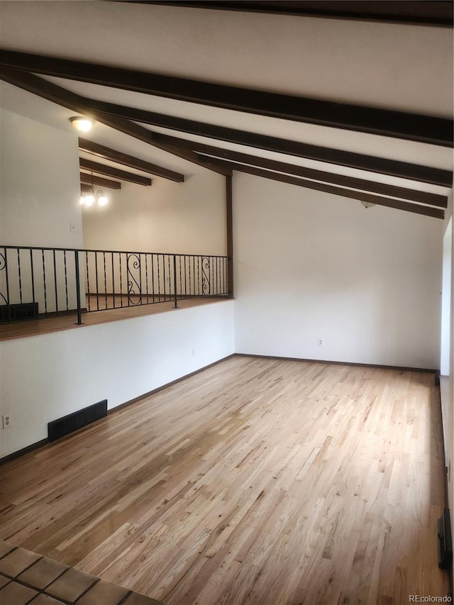 unfurnished room featuring vaulted ceiling with beams and wood-type flooring