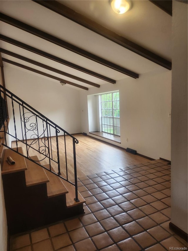 staircase featuring beam ceiling and tile patterned floors