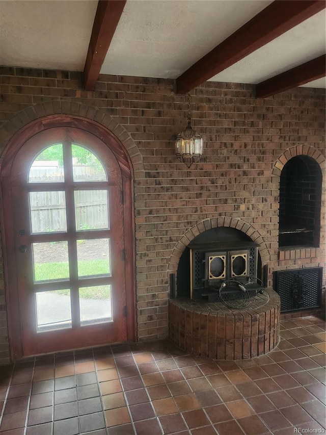 interior space featuring plenty of natural light, brick wall, and dark tile patterned floors