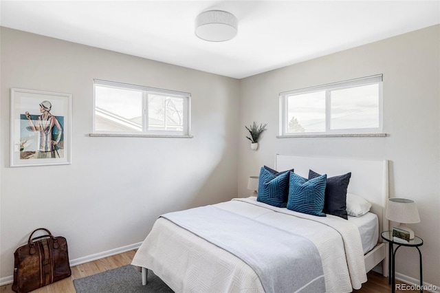 bedroom with baseboards and wood finished floors