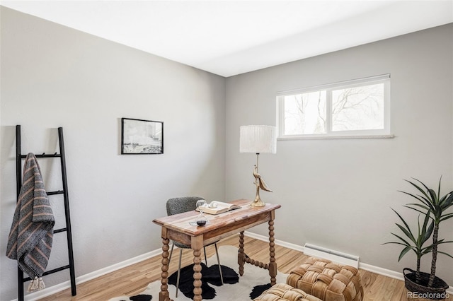 office featuring a baseboard radiator, light wood-style flooring, and baseboards