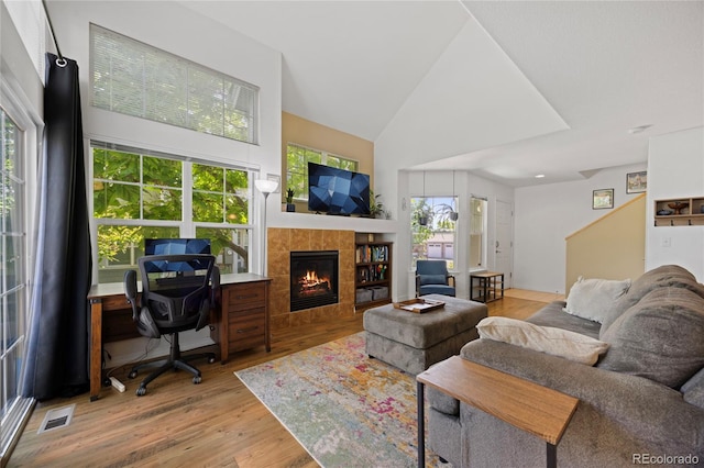 12812 Jasmine St Unit C, Thornton, CO 80602 - living area featuring light wood-style flooring, a fireplace, high vaulted ceiling, and an office area