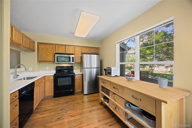 12812 Jasmine St Unit C, Thornton, CO 80602 - kitchen with black appliances, light wood-style floors, open shelves, and butcher block counters