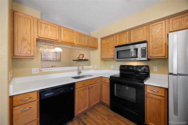 12812 Jasmine St Unit C, Thornton, CO 80602 - kitchen with black appliances, wood finished floors, light countertops, and a textured ceiling