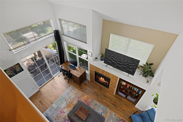 12812 Jasmine St Unit C, Thornton, CO 80602 - living room featuring a towering ceiling, wood finished floors, and a tiled fireplace