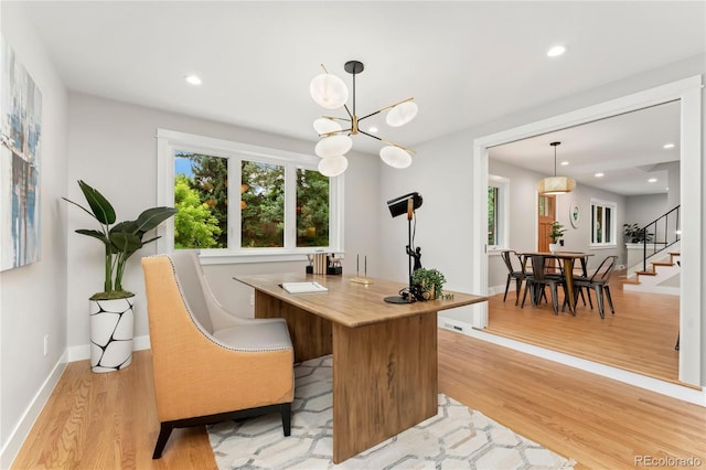 home office featuring a notable chandelier and light hardwood / wood-style flooring