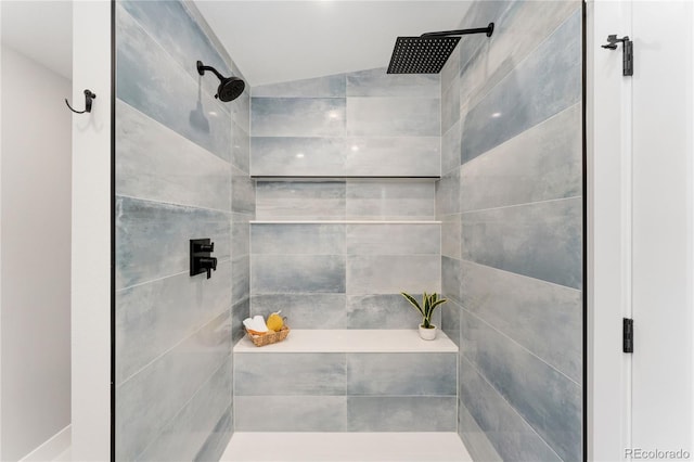 bathroom featuring tiled shower and vaulted ceiling