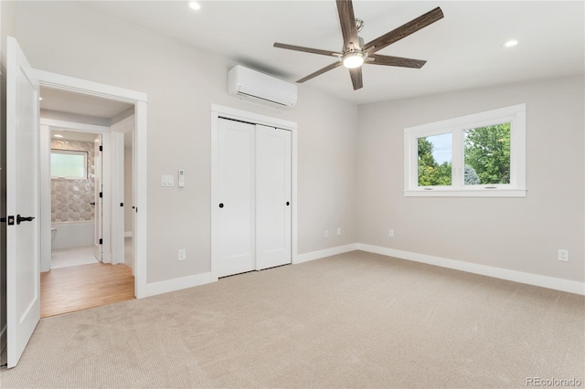 unfurnished bedroom with a closet, light colored carpet, an AC wall unit, and ceiling fan