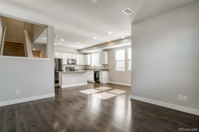 16069 E Elk Dr, Denver, CO 80239 - unfurnished living room featuring dark wood finished floors, stairway, and recessed lighting