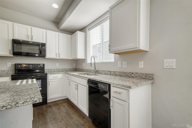 16069 E Elk Dr, Denver, CO 80239 - kitchen with black appliances, dark wood-type flooring, white cabinetry, and light stone counters