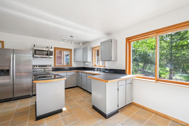 429 Overlook Dr, Bailey, CO 80421 - kitchen with stainless steel appliances, gray cabinets, a peninsula, dark countertops, and light tile patterned floors