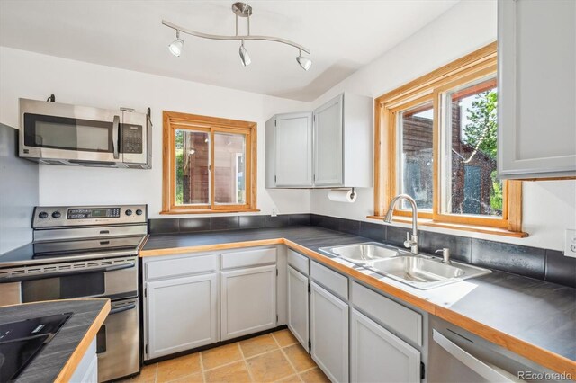 429 Overlook Dr, Bailey, CO 80421 - kitchen with stainless steel appliances, plenty of natural light, light tile patterned floors, and dark countertops