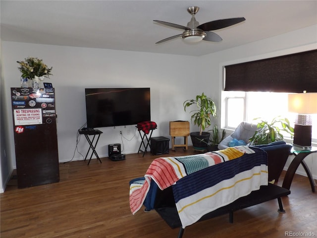 living room featuring ceiling fan and dark wood-type flooring