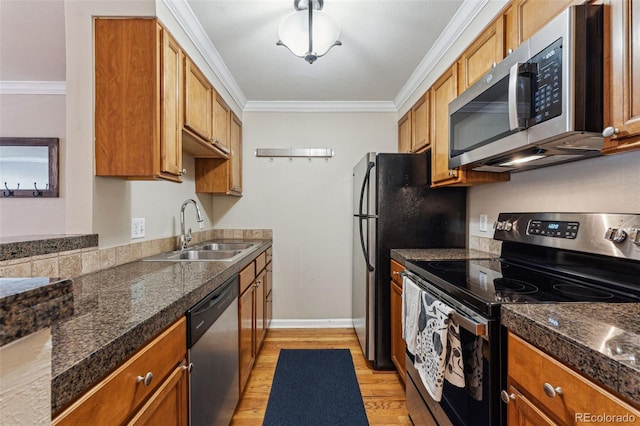 kitchen with brown cabinets, ornamental molding, stainless steel appliances, and a sink