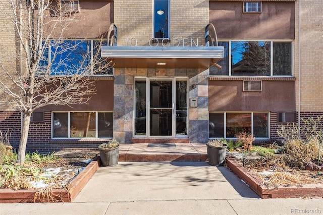 entrance to property with a patio area and brick siding