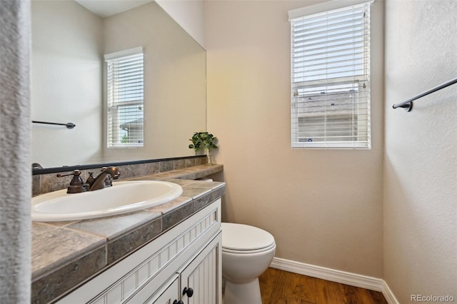 10402 Capital Peak Way, Peyton, CO 80831 - half bathroom featuring baseboards, vanity, wood finished floors, and toilet