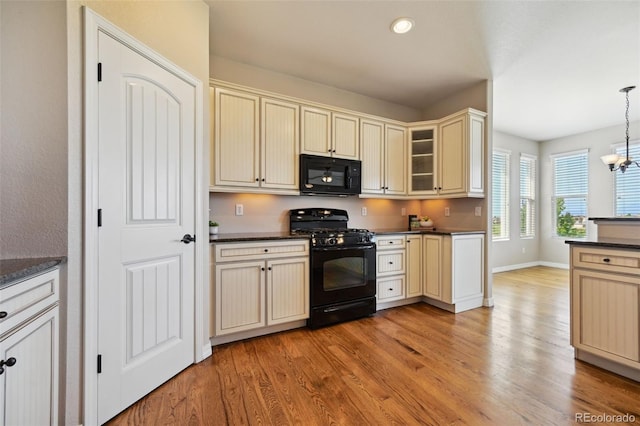 10402 Capital Peak Way, Peyton, CO 80831 - kitchen featuring black appliances, cream cabinetry, dark countertops, light wood finished floors, and recessed lighting