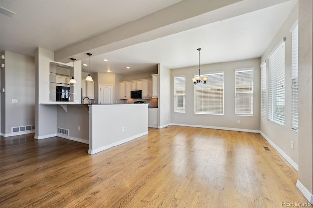 10402 Capital Peak Way, Peyton, CO 80831 - kitchen featuring a chandelier, light wood-style floors, baseboards, black microwave, and recessed lighting