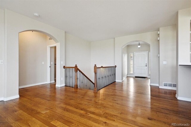 10402 Capital Peak Way, Peyton, CO 80831 - unfurnished room featuring arched walkways, wood finished floors, and a smoke detector