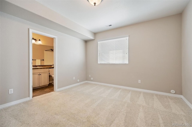 10402 Capital Peak Way, Peyton, CO 80831 - unfurnished bedroom with light colored carpet, baseboards, and connected bathroom