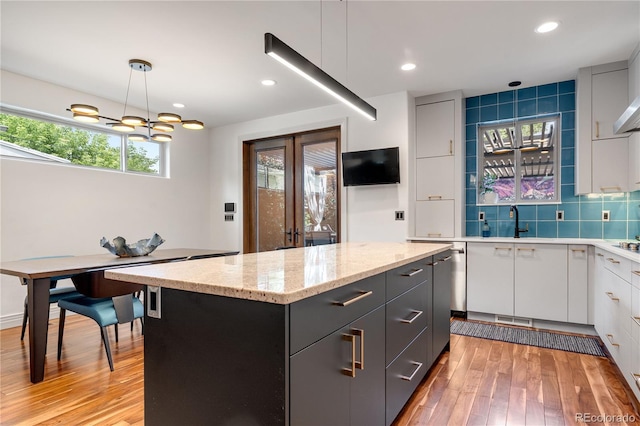 2334 Lowell Blvd, Denver, CO 80211 - kitchen with light wood-style flooring, a center island, white cabinets, tasteful backsplash, and recessed lighting