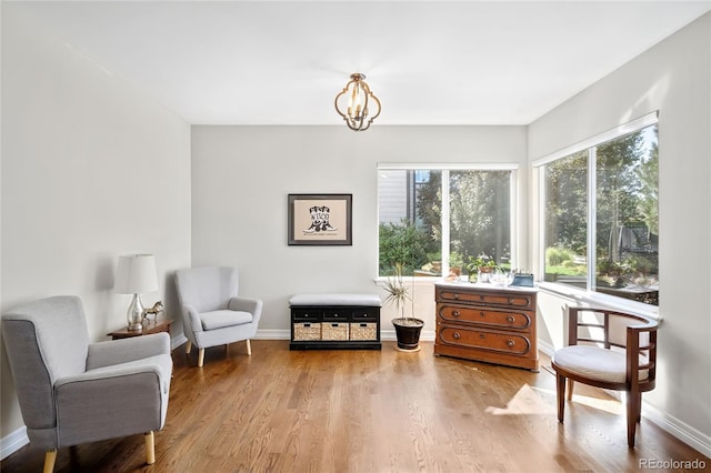 sitting room featuring an inviting chandelier and light wood-type flooring