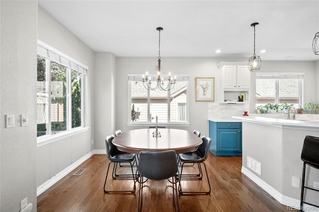 dining room featuring dark wood-type flooring and an inviting chandelier