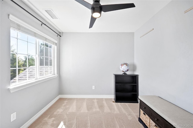 interior space with light carpet and ceiling fan