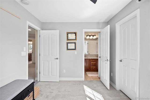 bedroom featuring connected bathroom and light colored carpet