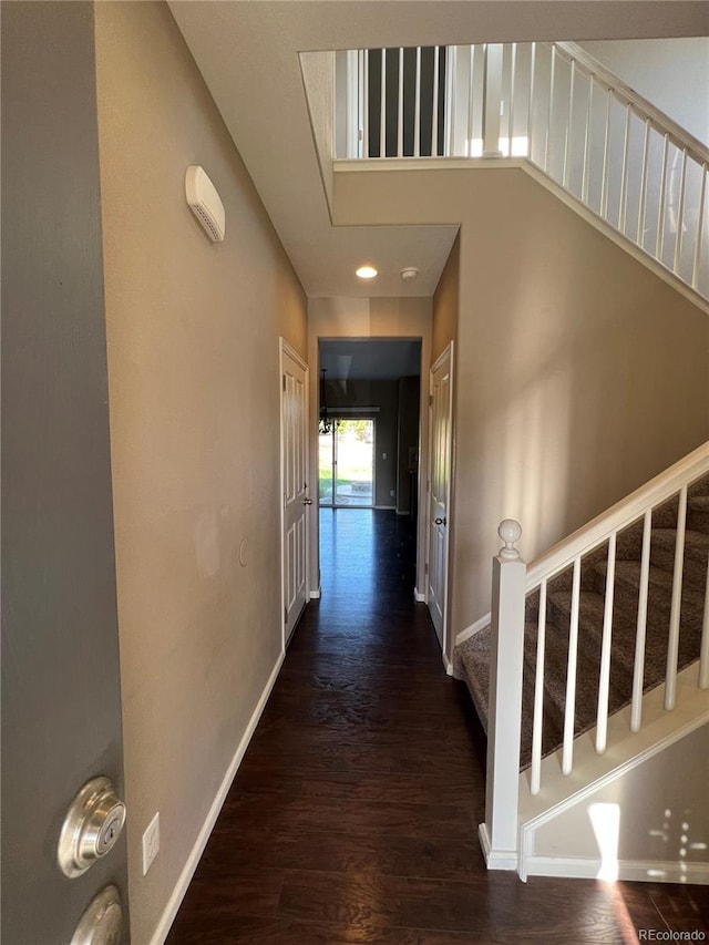 hall featuring a high ceiling and dark hardwood / wood-style floors