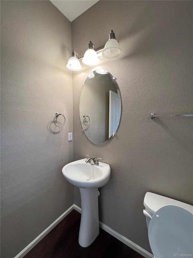 bathroom with hardwood / wood-style flooring and toilet