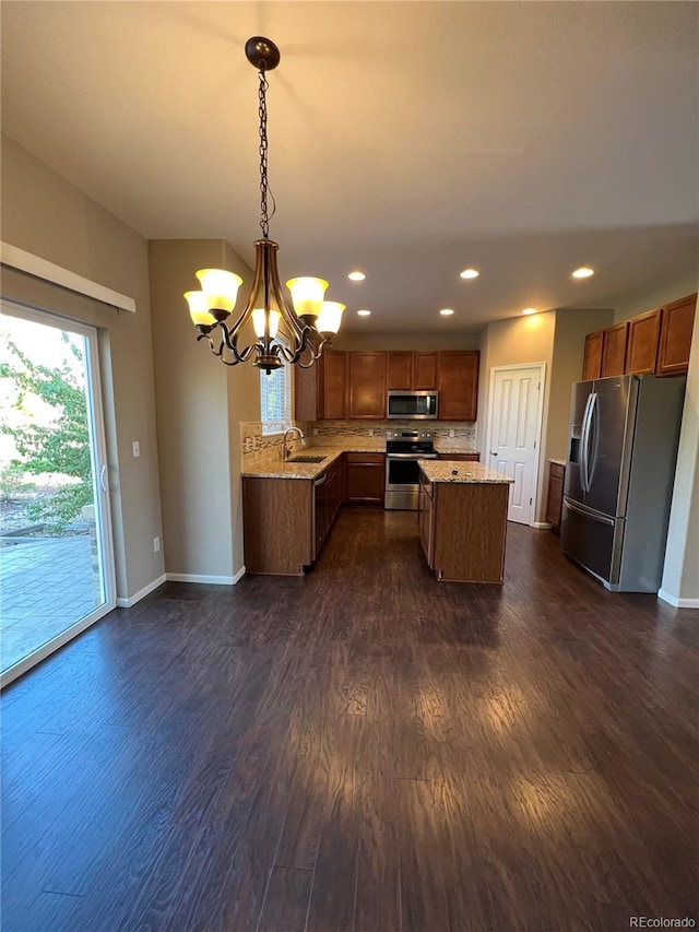 kitchen with a chandelier, sink, stainless steel appliances, decorative light fixtures, and dark hardwood / wood-style flooring