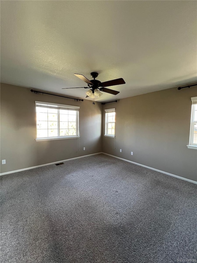 empty room with carpet floors, a textured ceiling, and ceiling fan