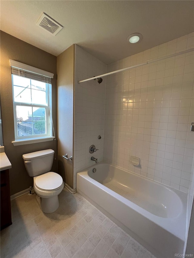 full bathroom with tiled shower / bath combo, vanity, and toilet