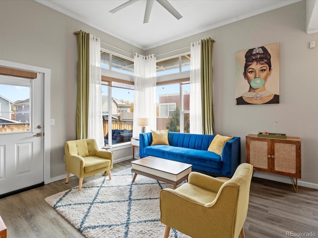 living area featuring hardwood / wood-style floors, ornamental molding, and ceiling fan