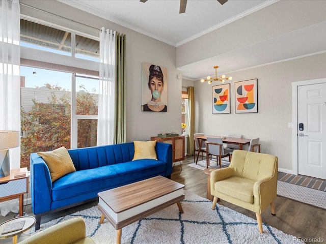 living room featuring hardwood / wood-style flooring, crown molding, and ceiling fan with notable chandelier