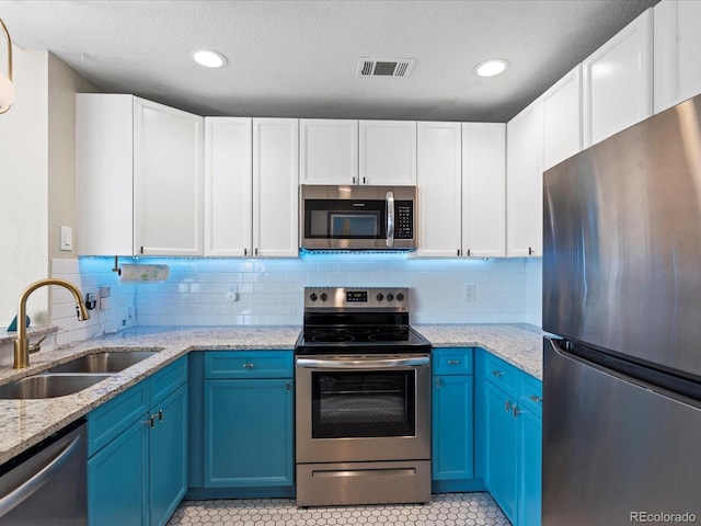 kitchen with blue cabinets, sink, white cabinetry, and appliances with stainless steel finishes